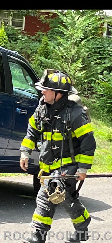 Crew member from E-7 performing size up at residential Fire in Sound Beach 